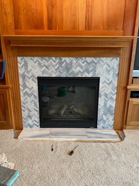 Grey marble herringbone fireplace surround with cherry mantel
