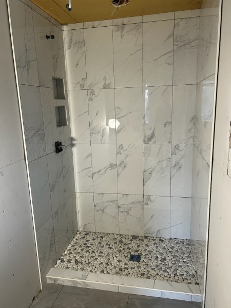 Marble shower with pebble floor
